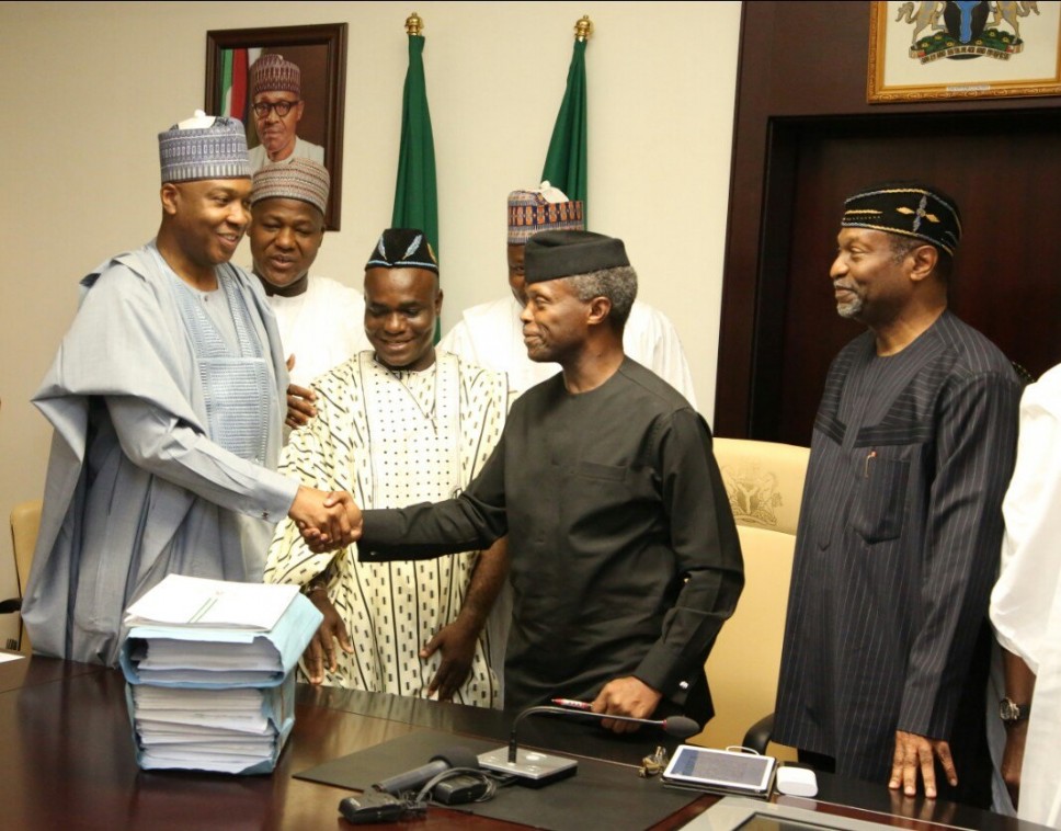 Acting president, Yemi Osinbajo shakes Bukola Saraki after signing the 2017 budget at the State House