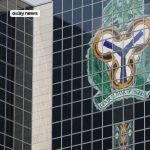 Central Bank of Nigeria headquarters building with the CBN coat of arms displayed on its glass facade in Abuja, Nigeria
