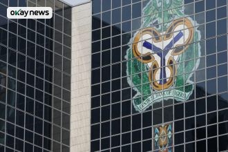 Central Bank of Nigeria headquarters building with the CBN coat of arms displayed on its glass facade in Abuja, Nigeria